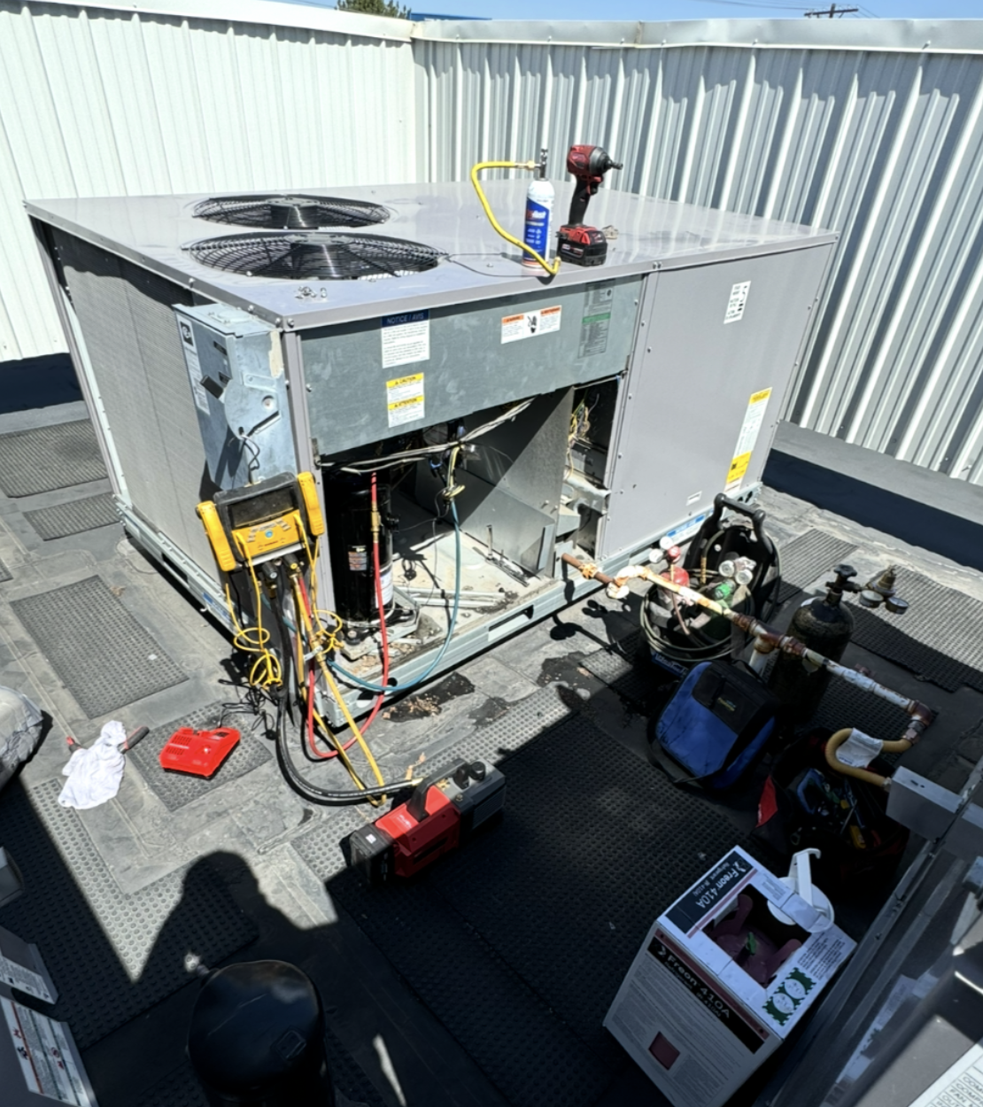 Commercial rooftop HVAC unit during professional service and repair