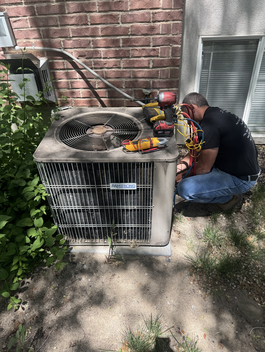 HVAC technician servicing an outdoor air conditioning unit