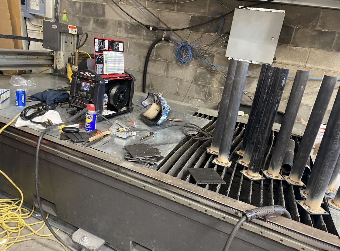 CNC plasma cutting table and welding equipment in a sheet metal fabrication shop