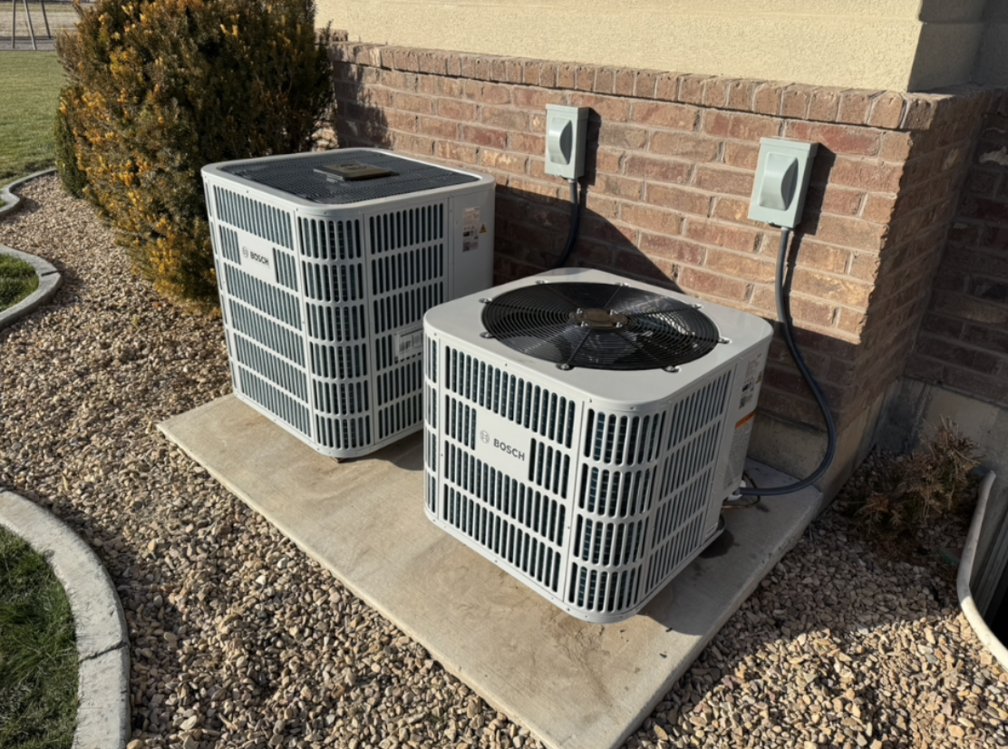 Dual Bosch outdoor heat pump units installed on a concrete pad