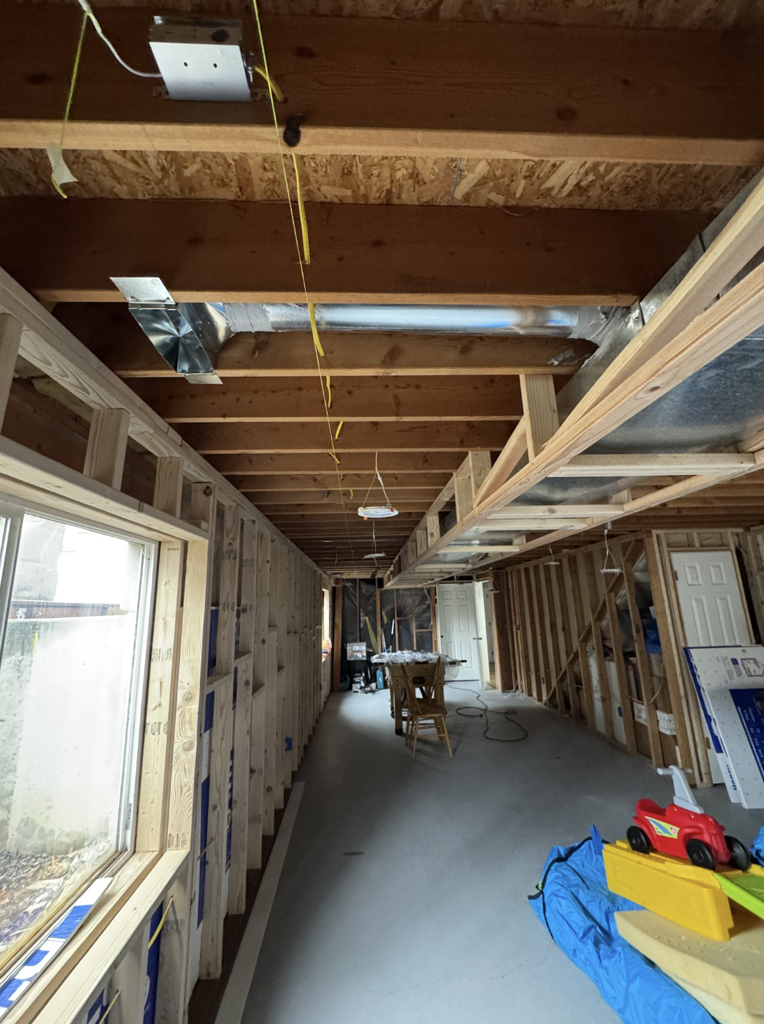 Unfinished basement with exposed HVAC ductwork during a remodel