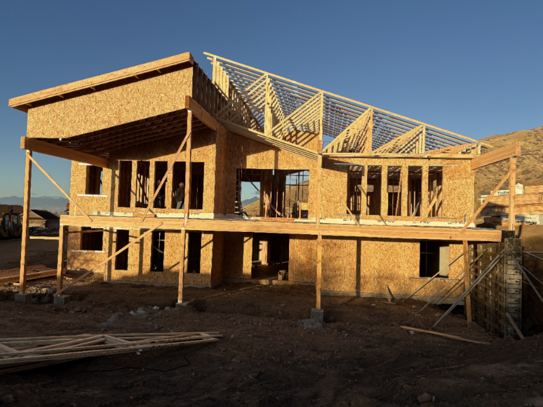 Modern residential home under construction with wood framing and roof trusses
