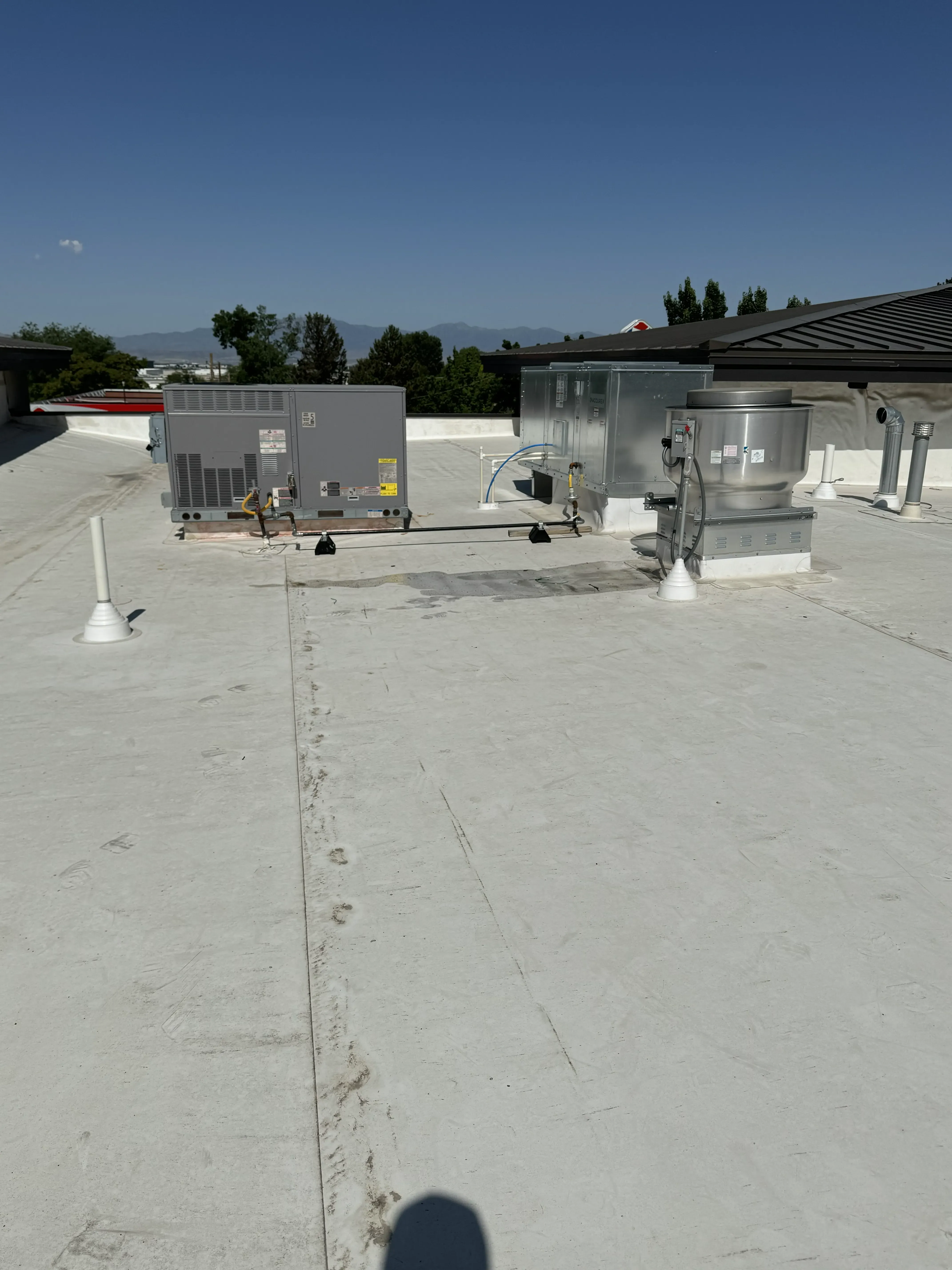 Rooftop package unit next to an exhaust fan