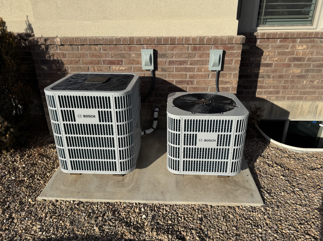 Dual Bosch outdoor HVAC condenser units installed on a residential concrete pad