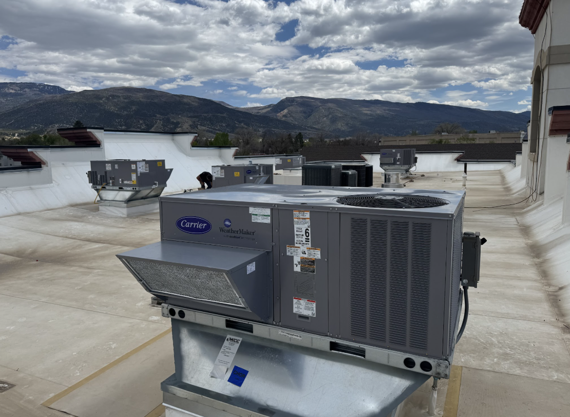 Commercial Carrier rooftop HVAC units on a flat roof with Utah mountains in the background