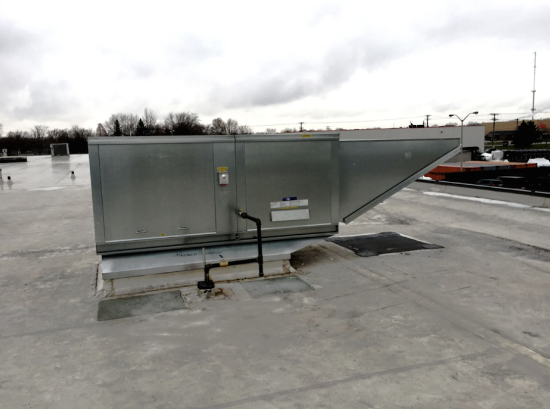 Galvanized steel commercial rooftop ventilation unit on a flat roof